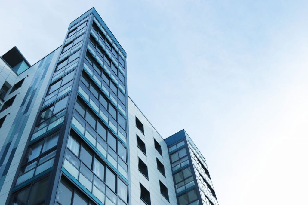 pexels-photo-323705 Low-angle view of a modern glass skyscraper against a clear sky in Poole, UK.