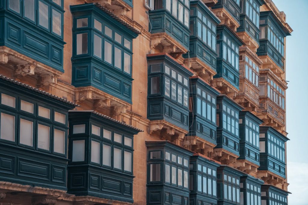 pexels-photo-6179132 Explore the vibrant, traditional Maltese architecture highlighted by colorful enclosed balconies in this striking image.