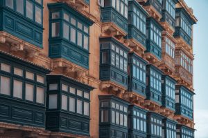 Explore the vibrant, traditional Maltese architecture highlighted by colorful enclosed balconies in this striking image.
